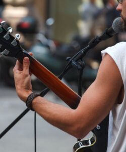 Homem em apresentação de guitarra e voz