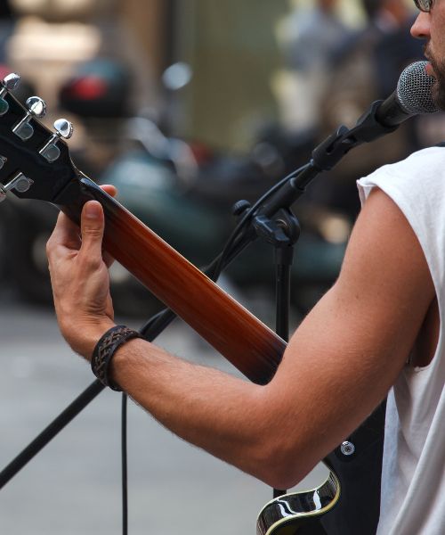 Homem em apresentação de guitarra e voz